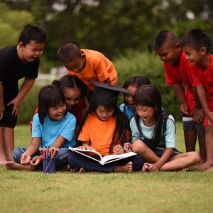 group-children-lying-reading-grass-field_1150-3900